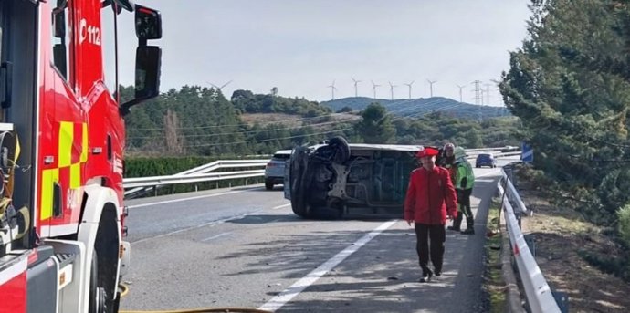 Un agente de la Policía Foral junto al vehículo accidentado.