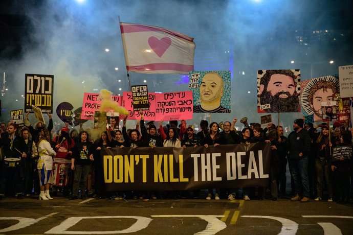 February 15, 2025, Tel Aviv, Israel: Israeli hostages family members and supporting crowd hold a sign that reads 'Dont kill the deal' while painting the road with a caption that reads 'First of all - the hostages. All of them now!'. Thousands of Israelis 