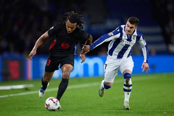 Archivo - Jules Kounde of FC Barcelona competes for the ball with Ander Barrenetxea of Real Sociedad during the LaLiga EA Sports match between Real Sociedad and FC Barcelona at Reale Arena on November 10, 2024, in San Sebastian, Spain.