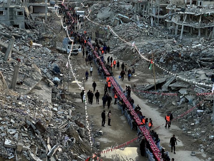 1º de março de 2025, Rafah, Faixa de Gaza, Território Palestino: Palestinos quebram o jejum comendo as refeições do Iftar durante o mês sagrado do Ramadã, perto dos escombros de edifícios, em meio a um cessar-fogo entre Israel e o Hamas, em Rafah, no sul 