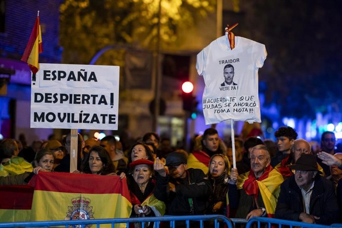 Archivo - Un manifestante muestra una camiseta aludiendo a Pedro Sánchez y varias personas con carteles y banderas de España, durante una manifestación contra la amnistía frente a la sede del PSOE en Ferraz, a 17 de noviembre de 2023, en Madrid (España).