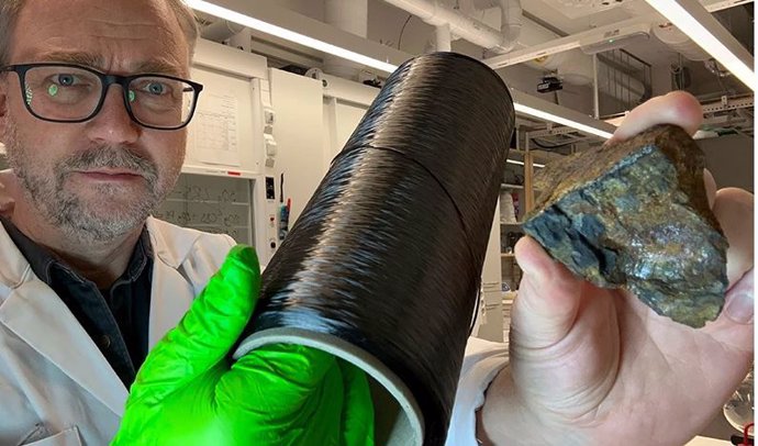 Richard Olsson no laboratório segurando duas fontes de grafeno, um carretel de fibra de carbono e um pedaço de grafite extraído.