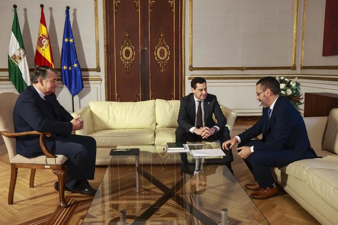 El presidente de la Junta, Juanma Moreno, (2i) junto al alcalde de la Línea, José Juan Franco, (d) y el consejero de Presidencia, Interior, Diálogo Social y Simplificación Administrativa, Antonio Sanz, (i) durante la reunión en el Palacio de San Telmo. 