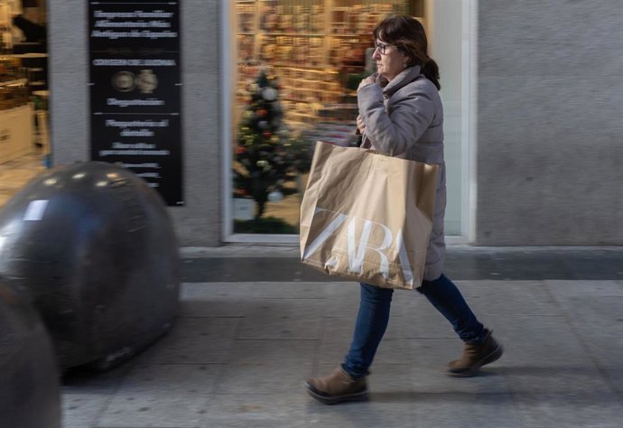 Archivo - Varias personas con bolsas durante las rebajas de enero, a x de enero de 2025, en Madrid (España). 