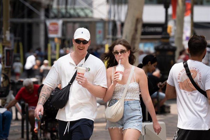 Archivo - Varias personas pasean por una ciudad española.