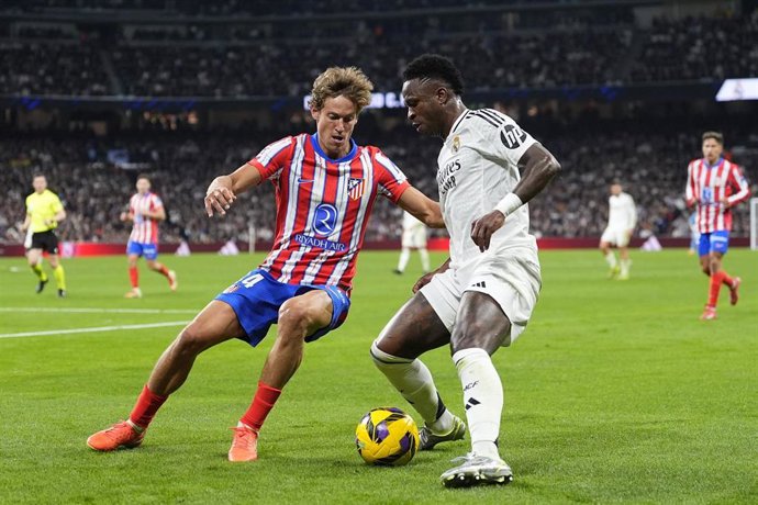 Vinícius Júnior (Real Madrid) y Marcos Llorente (Atlético de Madrid) durante el derbi madrileño liguero en el Santiago Bernabéu.
