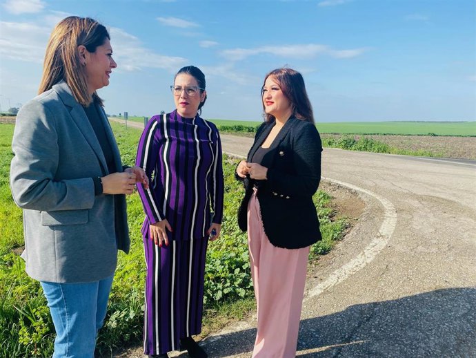 La parlamentaria socialista conversa con la teniente de alcalde en el cruce de la A-8100 con la SE-3200 acerca del mal estado de la carretera de titularidad autonómica.