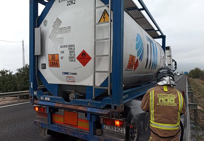 Un bombero del CEIS extingue el fuego originado en el sistema de frenado de un camión cisterna en Alcantarilla