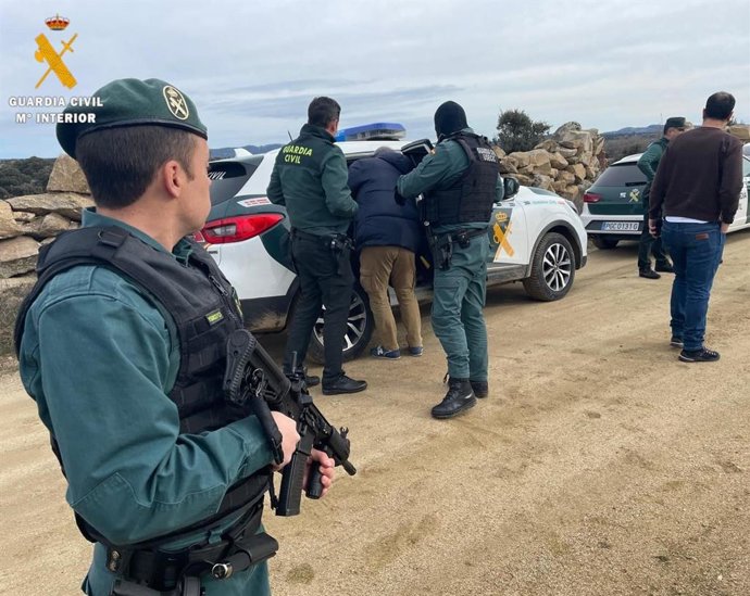 Agentes introducen en el coche a uno de los detenidos.