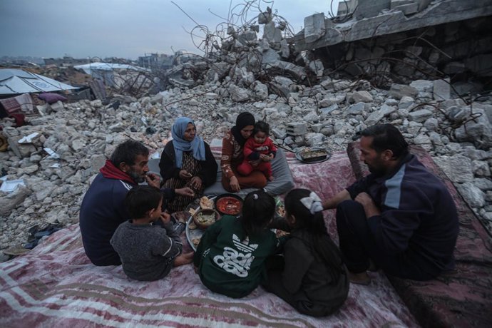 Uma família palestina em pé nas ruínas de sua casa na cidade de Beit Lahia, no norte da Faixa de Gaza, destruída pelo exército israelense durante sua ofensiva contra o enclave (arquivo).