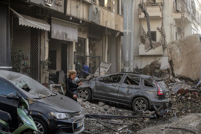 Archivo - Arquivo - 22 de novembro de 2024, Beirute, Beirute, Líbano: Uma mulher caminha entre destroos e carros destruídos no local onde um prédio desabou após um ataque aéreo israelense na área de Chiyah, nos arredores do subúrbio sul de Beirute. Isr