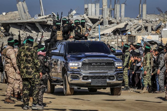 15 de fevereiro de 2025, Territórios Palestinos, Khan Younis: combatentes das brigadas da Jihad Islâmica e Ezz al-Din Al-Qassam, a ala militar do Hamas, chegam para entregar três reféns israelenses a representantes da Cruz Vermelha no sul da Faixa de Gaza