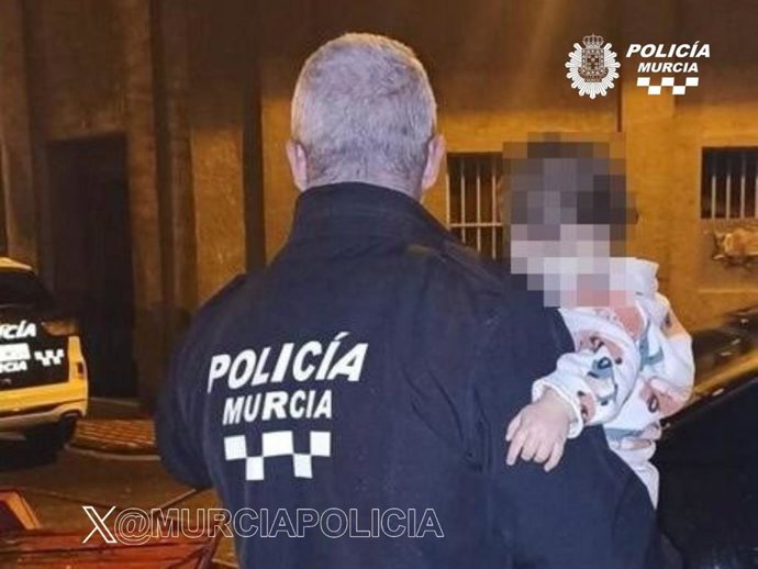 Un agente de la Policía Local de Murcia traslada al exterior a uno de los menores