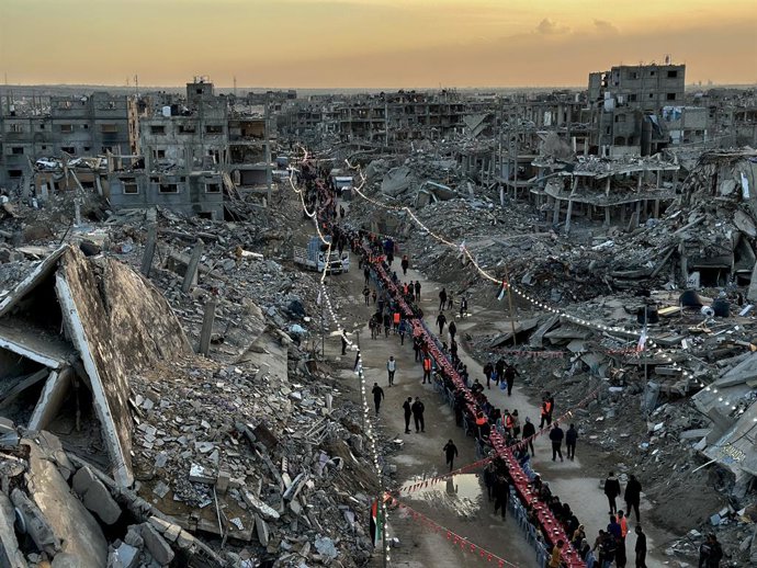 01 de março de 2025, Territórios Palestinos, Rafah: Os palestinos quebram o jejum com refeições iftar perto dos escombros de edifícios durante o primeiro dia do mês sagrado do Ramadã, em meio a um cessar-fogo entre Israel e o Hamas. Foto: Doaa El-Baz/APA 