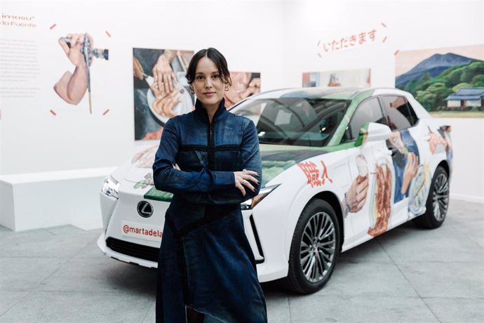 La artista Marta de la Fuente posa junto al Lexus RZ en el estand de Lexus en Art Madrid, en la Galería de Cristal del Palacio de Cibeles, a 6 de marzo de 2025, en Madrid (España). 