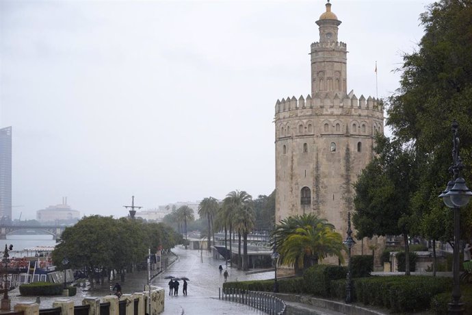 Varias se protegen de la lluvia con un paraguas. Imagen de archivo. 