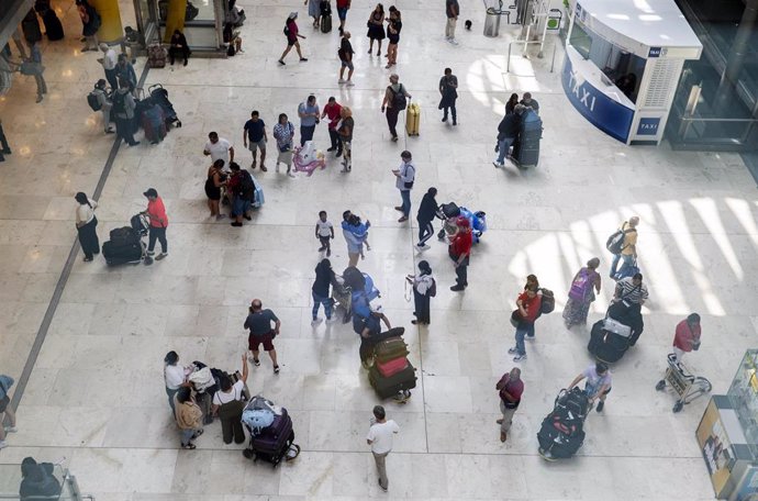 Archivo - Varias personas con maletas en la terminal T4 del aeropuerto Adolfo Suárez Madrid-Barajas 