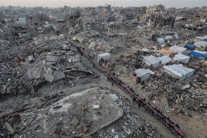 Palestinos se reúnen entre edificios destruidos para romper el ayuno juntos durante el mes sagrado de Ramadán en el campamento de refugiados de Yabalia, en el norte de la Franja de Gaza