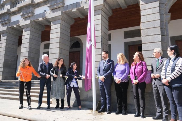 La alcaldesa de Las Palmas de Gran Canaria, junto a miembros de su gobierno, y ante ediles de la oposición iza la bandera feminista en las Casas Consistoriales
