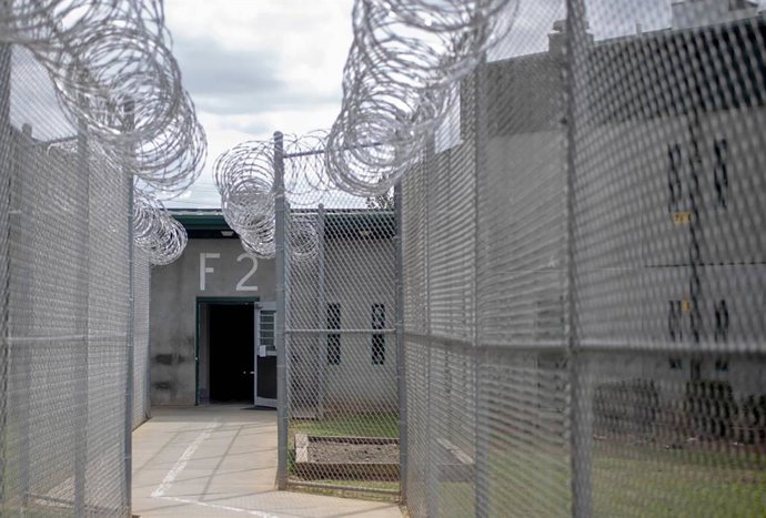 Archivo - Arquivo - 24 de fevereiro de 2023: Cercas de arame farpado guiam um caminho para um dormitório da Instituição Correcional Kirkland em Columbia, Carolina do Sul.