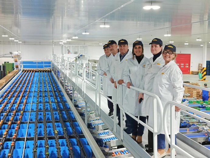 La consejera de Agua, Agricultura, Ganadería y Pesca, Sara Rubira, junto a los directivos de la SAT Perichán en la nueva calibradora para el procesado de producto que han instalado.