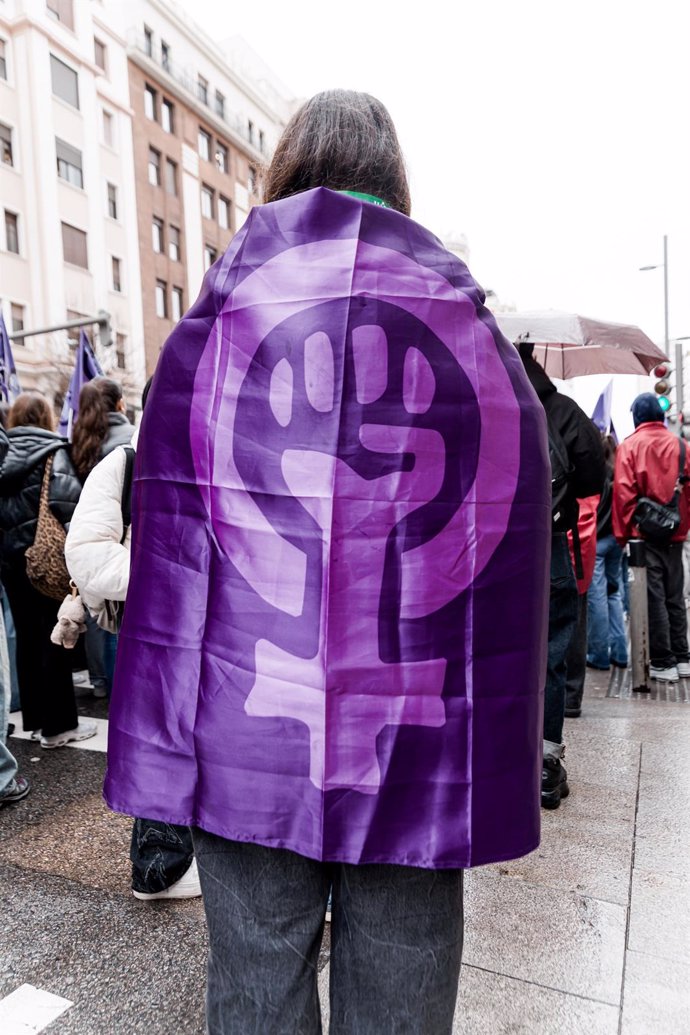 Una mujer con una bandera feminista durante una manifestación por el Día Internacional de la Mujer, 8M