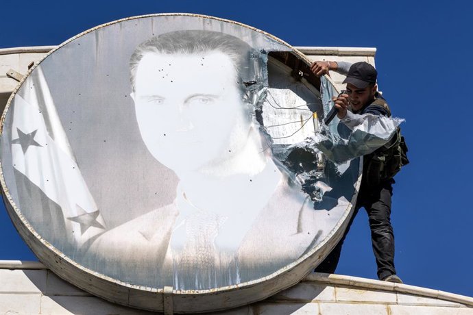 Archivo - Arquivo - 9 de dezembro de 2024, Damasco, Síria: Um rebelde local usa um carregador de fuzil de assalto para destruir uma foto do ex-presidente Bashar al-Assad em 9 de dezembro de 2024 no posto de fronteira entre a Síria e o Líbano, perto de Jda