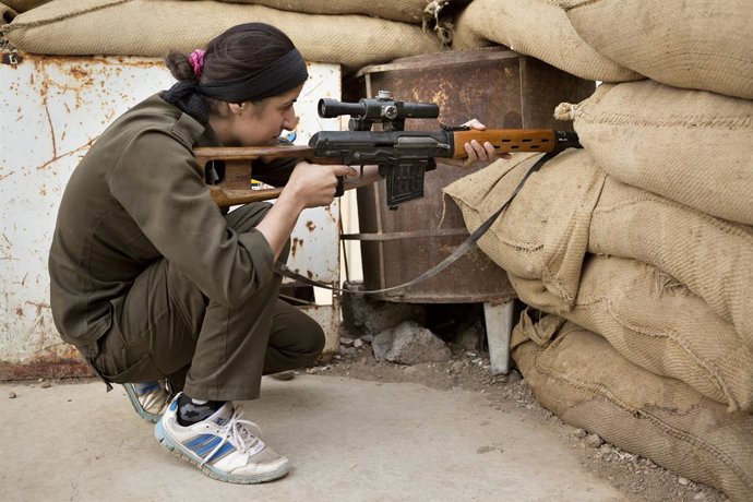Archivo - Arquivo - 28 de setembro de 2014 - Rabia, Governadoria de Ninewa, Iraque - Uma atiradora pertencente ao YPJ sírio-curdo mira no que ela acha que pode ser um atirador do Estado Islâmico mudando de posição na cidade fronteiriça iraquiana de Rabia.