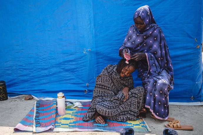 PEQUIM, 1º de março de 2025 -- Uma refugiada sudanesa penteia o cabelo de seu companheiro no assentamento de refugiados de Gorom, nos arredores de Juba, Sudão do Sul, em 27 de fevereiro de 2025. O assentamento de refugiados de Gorom atualmente abriga apro