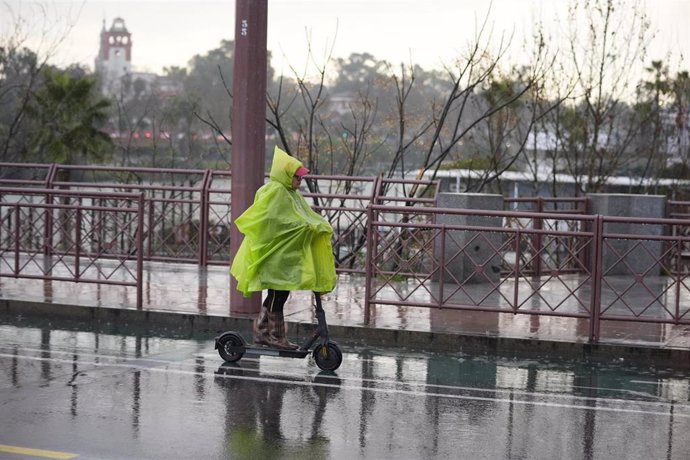 Una persona se protege de la lluvia con un impermeable. A 03 de marzo de 2025, en Sevilla (Andalucía, España).  (Imagen de archivo)