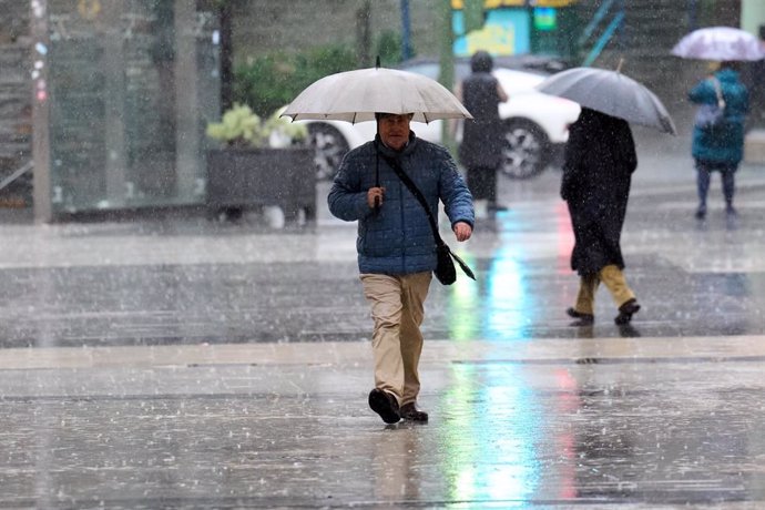 Archivo - Imagen de archivo de un hombre caminando bajo la lluvia. 