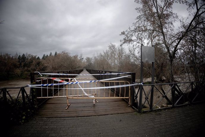 Una valla y cintas indican el cierre del paso a zonas inundables ante la crecida del caudal del río Henares, a 7 de marzo de 2025, en Alcalá de Henares, Madrid (España). 