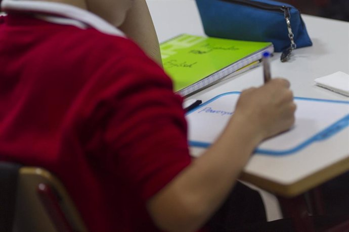 Un niño escribe durante una clase.