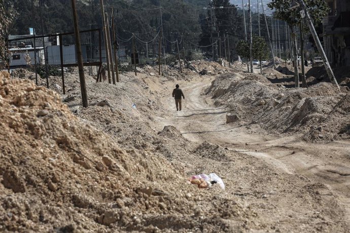 Um refugiado palestino caminha por uma rua destruída depois que sua casa foi demolida pelo exército israelense no campo de Nur Shams, na Cisjordânia.