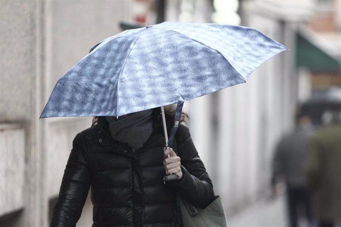 Archivo - Una mujer camina bajo un paraguas en un día de lluvia. Imagen de archivo