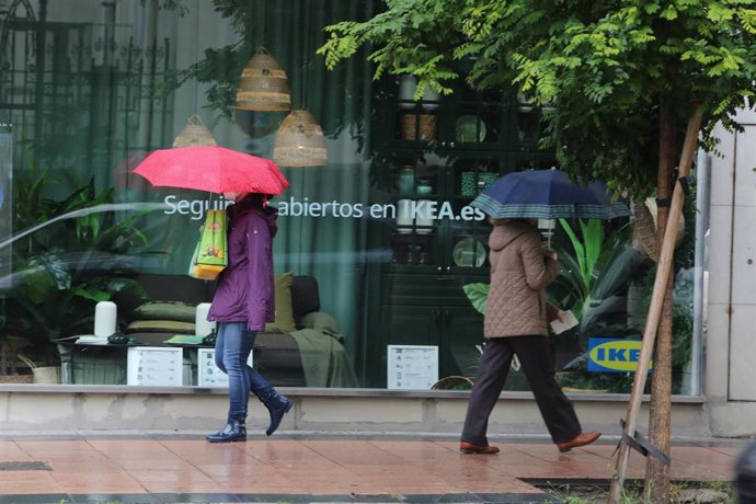 Archivo - Dos mujeres pasean con un paraguas en la capital en un día de lluvia y bajada de temperaturas en toda España, en que en gran parte de la Península y Baleares se espera nubosidad, a 14 de mayo de 2020.
