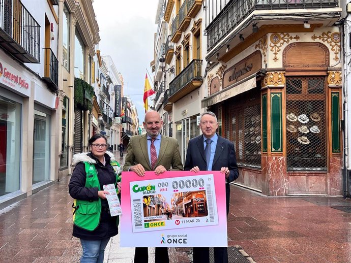 Manuel Alés, en el centro, junto al delegado territorial de la ONCE y una vendedora, con el cupón dedicado a la calle Sierpes.