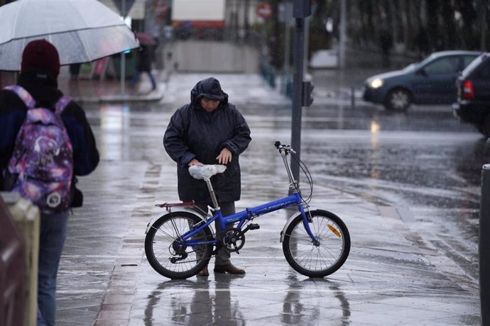 Una persona se protege de la lluvia con un impermeable. A 03 de marzo de 2025, en Sevilla (Andalucía, España). 