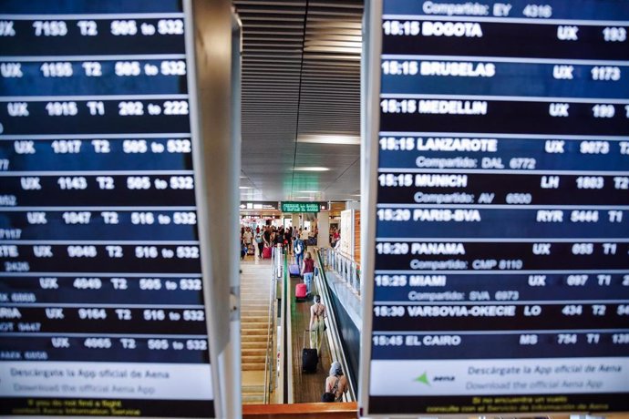 Archivo - Vista de pasajeros y pantallas de señalización de los vuelos en la Terminal 1 del Aeropuerto Adolfo Suárez Madrid Barajas, en Madrid (España). 
