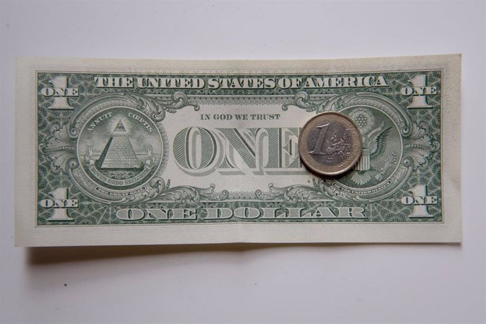Archivo - FILED - 12 July 2022, Berlin: A euro coin lies on a one dollar bill. The value of the euro dipped below that of the US dollar for the first time in 20 years on Wednesday. Photo: Paul Zinken/dpa