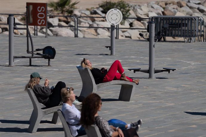 Archivo - Varias personas toman el sol en el paseo marítimo de la playa del Bogatell, a 15 de abril de 2024, en Barcelona, Catalunya (España). 