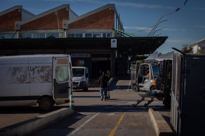Archivo - Dos trabajadores transportan mercancía en Mercabarna