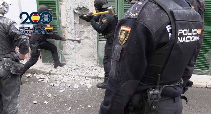 Agentes de la Policía Nacional tratan de entrar en un punto de venta de droga "bunkerizado" en La Soledad.