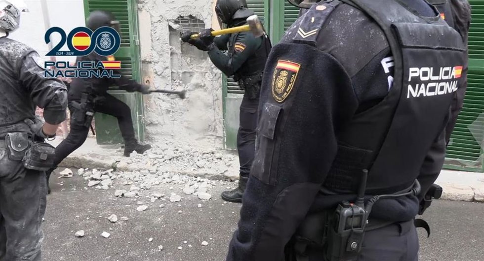 Agentes de la Policía Nacional tratan de entrar en un punto de venta de droga "bunkerizado" en La Soledad.