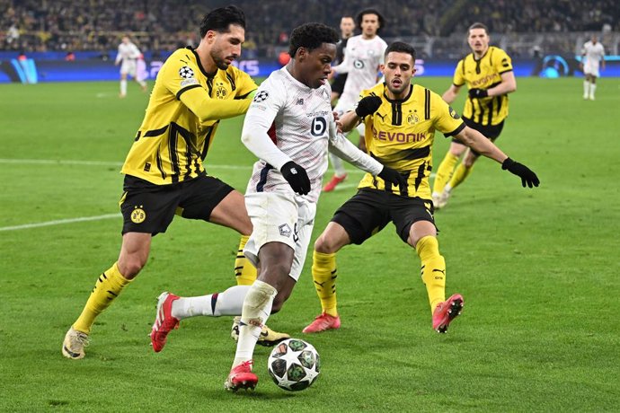 04 March 2025, Dortmund: Lille's Jonathan David and Borussia Dortmund's Yan Couto (R) battle for the ball during the UEFA Champions League round of 16 first-leg soccer match between Borussia Dortmund and LOSC Lille at Signal Iduna Park. Photo: Bernd Thiss