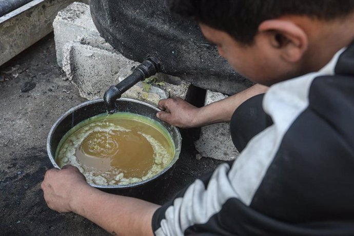 Trabajadores palestinos vierten combustible procesado a partir de plástico reciclado en la ciudad de Gaza
