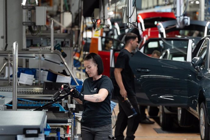Archivo - Empleados trabajan en la cadena producción de un coche.