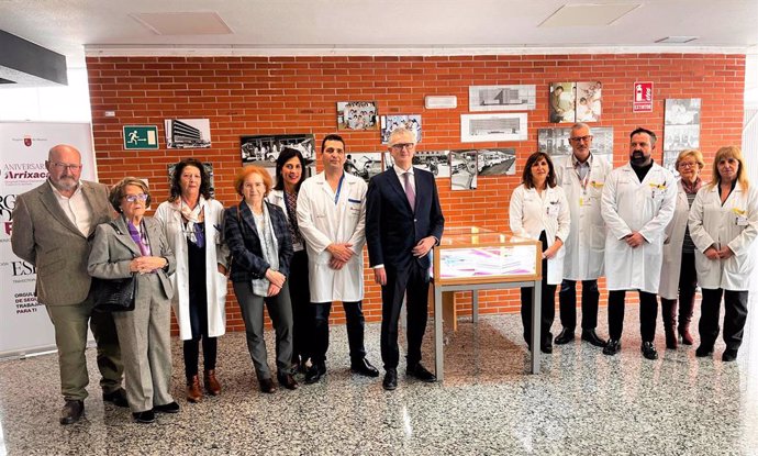 El consejero de Salud asiste junto a la conferenciante la investigadora Margarita del Val  (cuarta por la izquierda) a la inauguración de la exposición fotográfica por el 50 aniversario del hospital Virgen de la Arrixaca