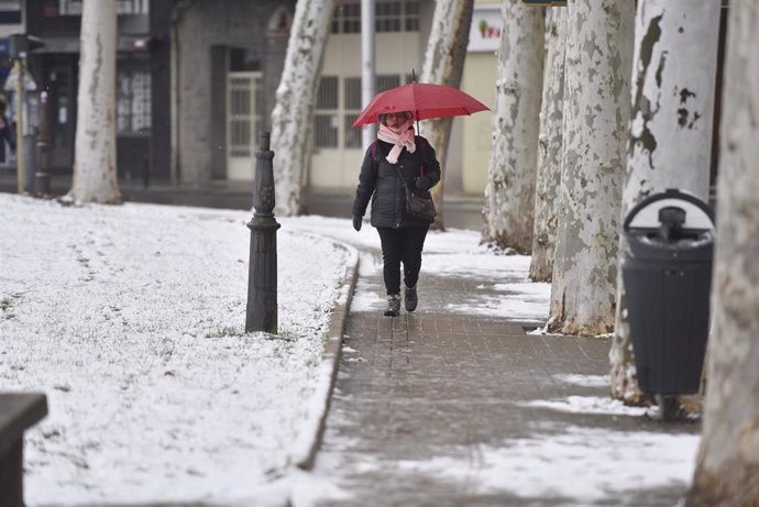 Archivo - Una mujer sujeta un paraguas mientras camina por una calle de nieve, a 10 de enero de 2024, en Jaca, Huesca, Aragón (España). 