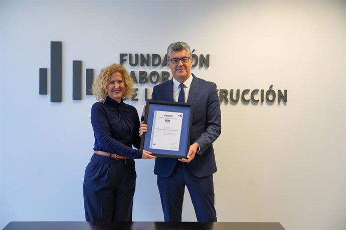 La directora de personas y organización de Aenor, Susana Pedrero, otorga el premio al director general de la Fundación Laboral de la Construcción, Julio Gil Iglesias.
